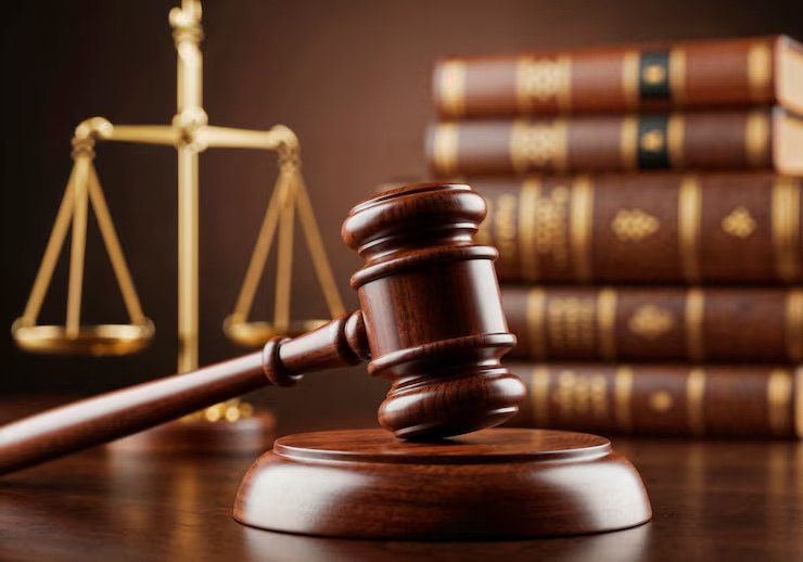 Gavel and sound block before the scales of justice and law books